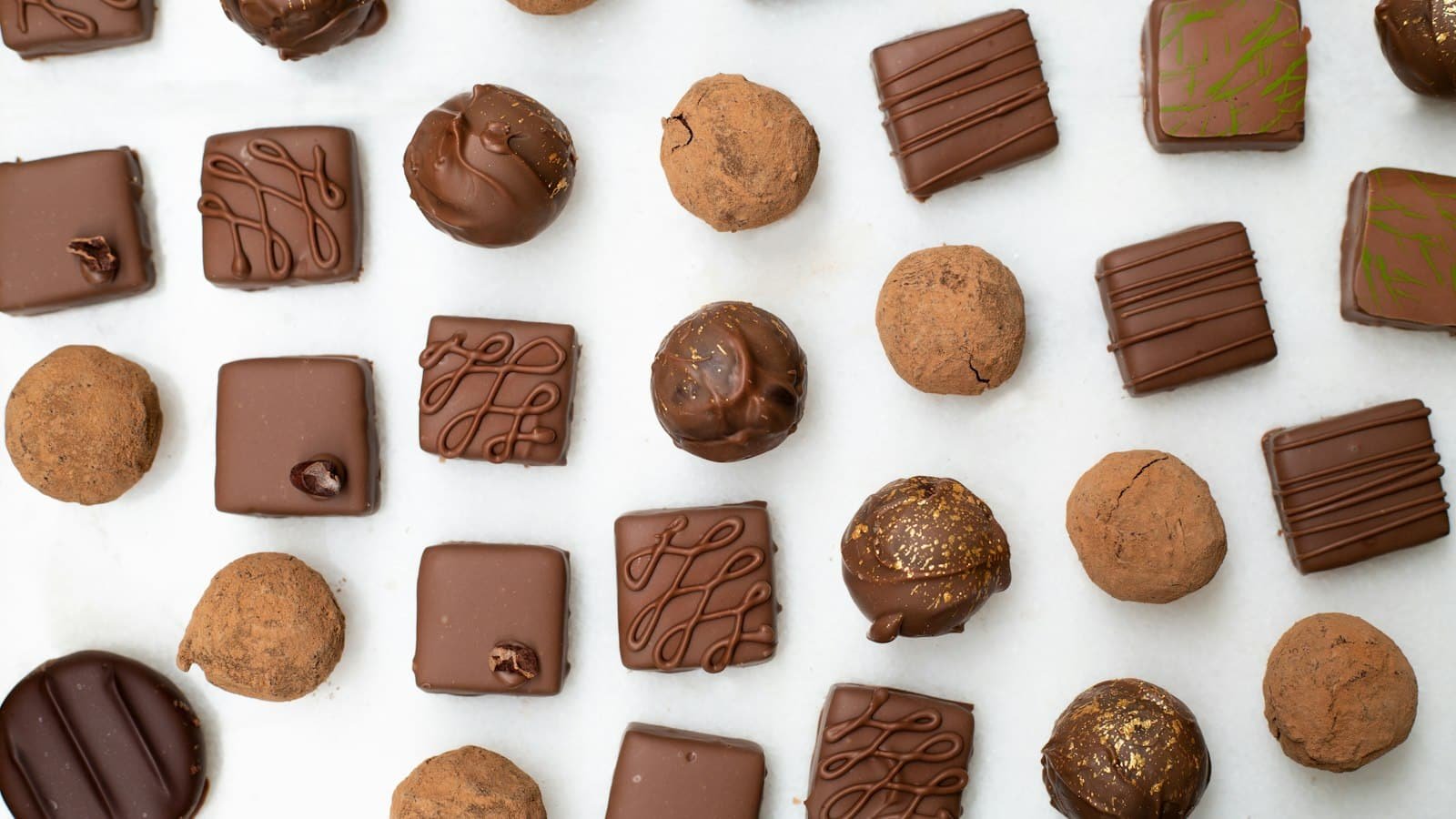 Assorted chocolates and truffles on a white surface