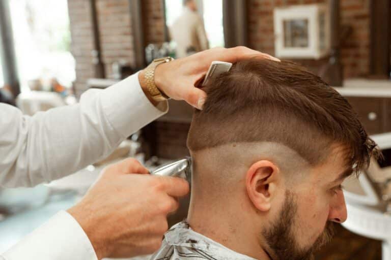 Barber cutting a bearded man's hair in a barbershop