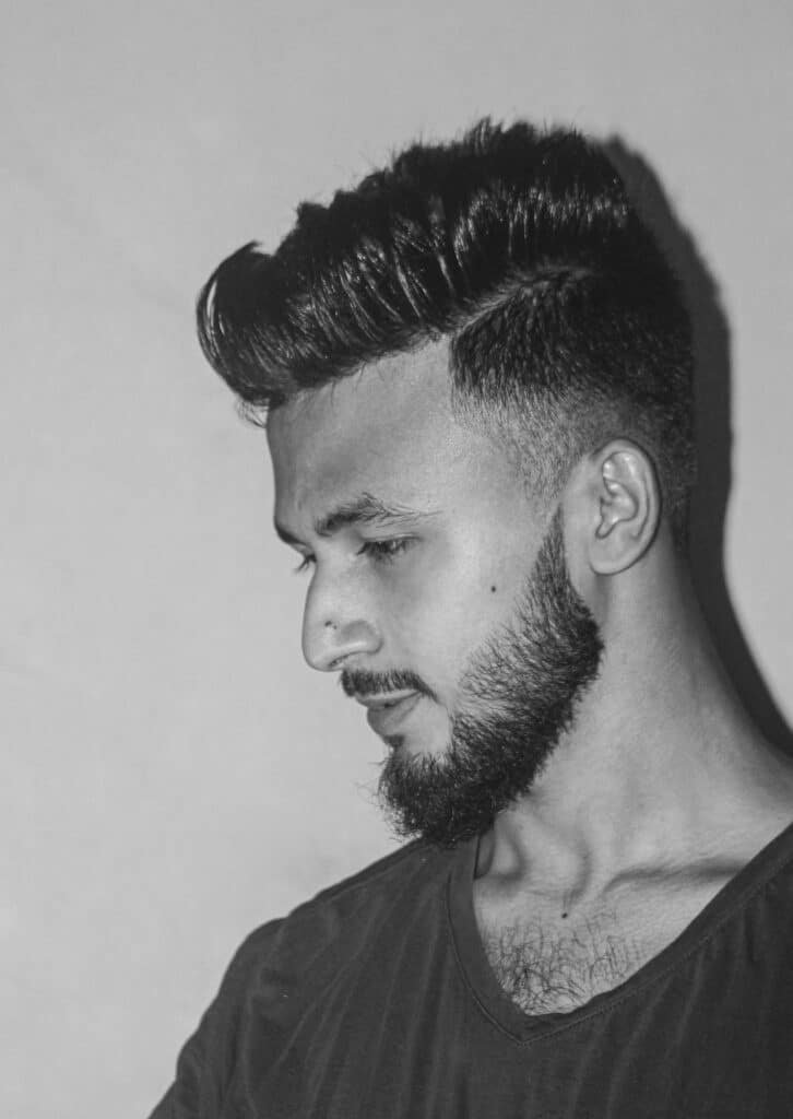 Black and white portrait of a man with styled hair and a trimmed beard