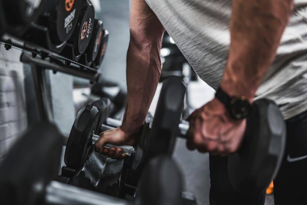 Close-up of a man lifting dumbbells from a rack