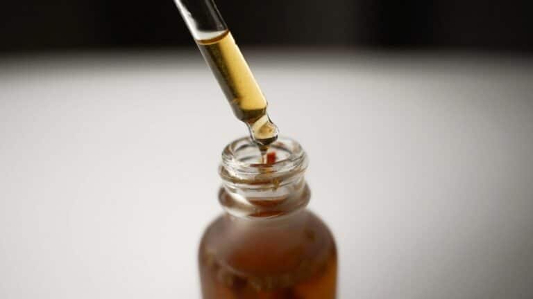 Dropper drawing serum from an amber bottle