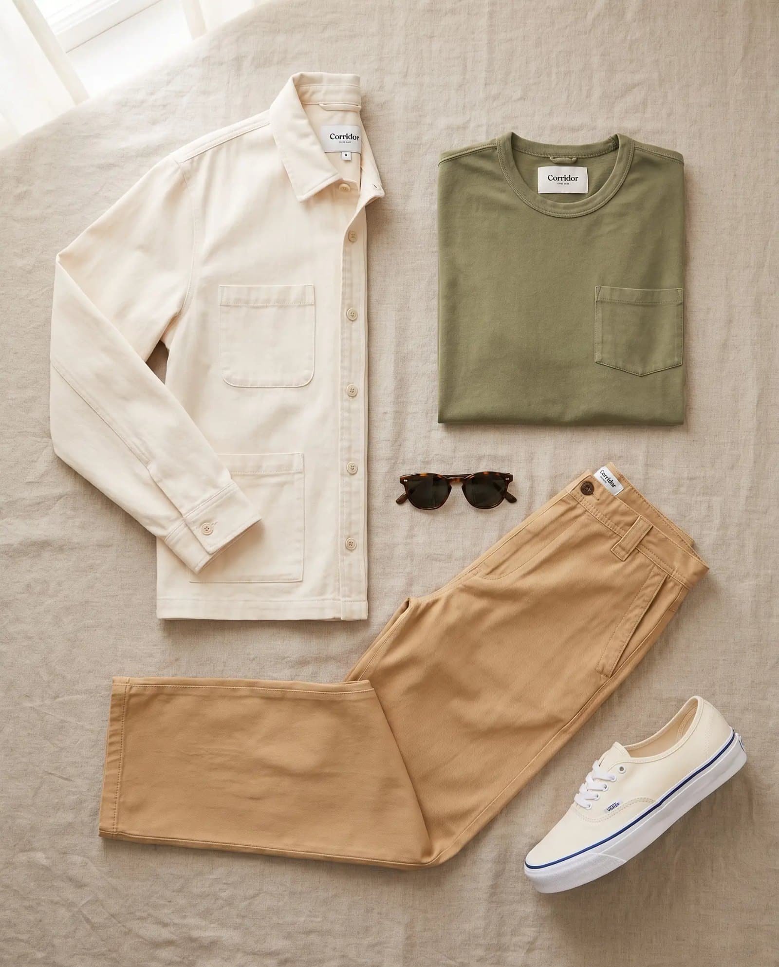 Flat lay of the Corridor Misha overshirt, olive tee, tan wide twill pants and off-white Vans