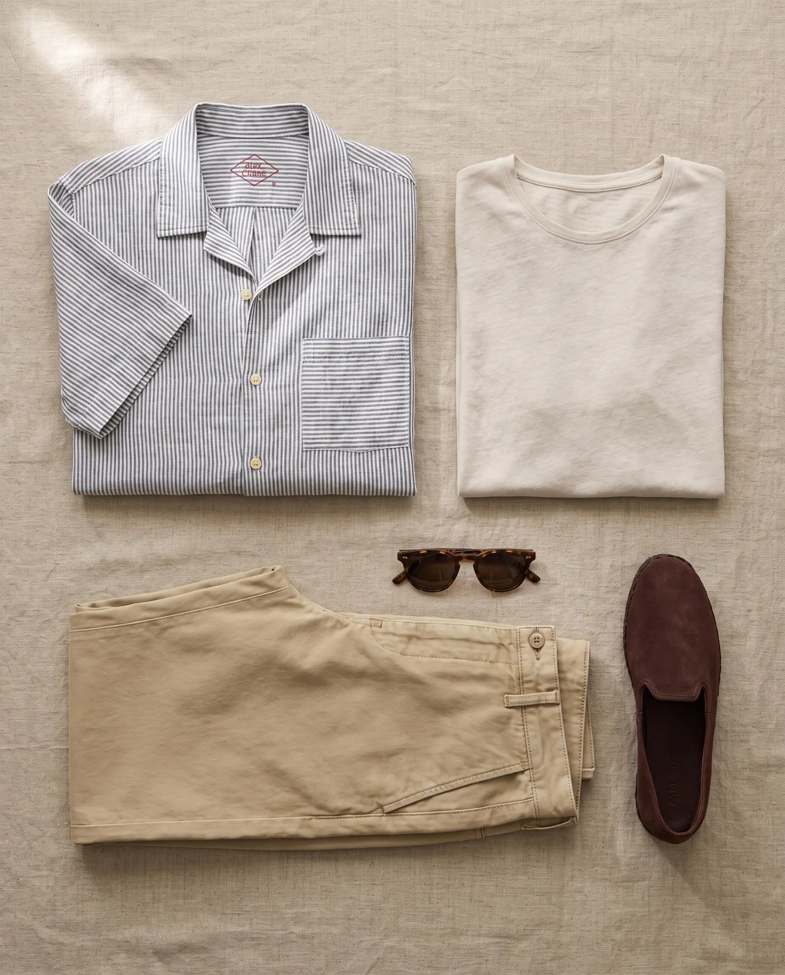 Flat lay of the Alex Crane Ola shirt, Sun Tee, faded khaki chino and Sabah slip-ons