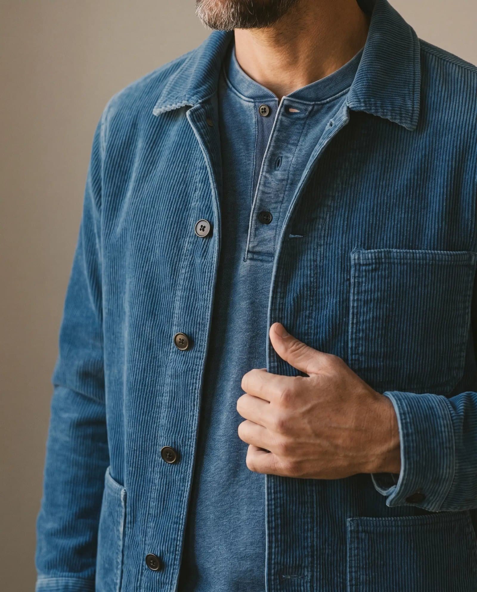 Close-up of the Taylor Stitch Ojai jacket in washed indigo corduroy showing the plain chest pocket and buttons