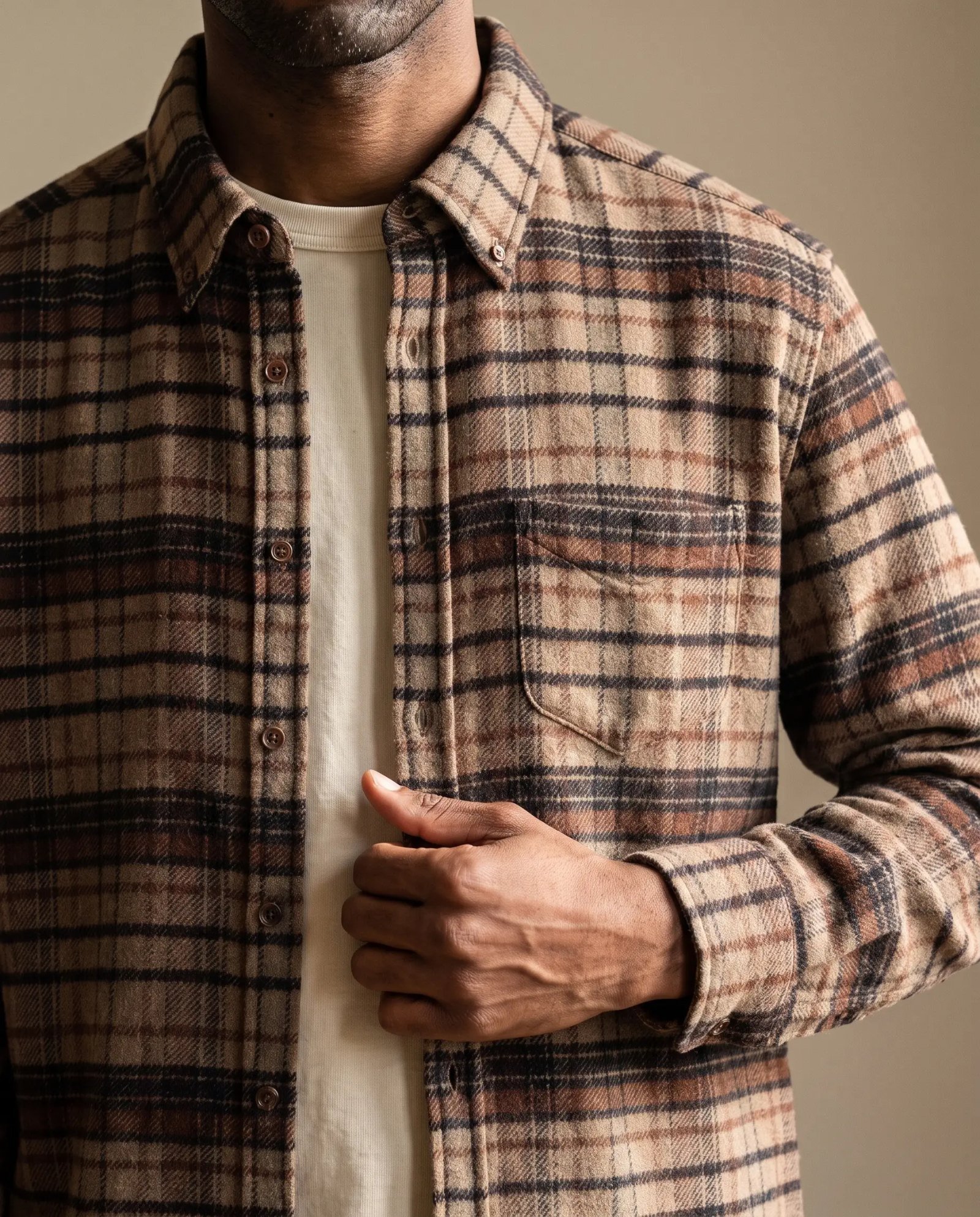 Close-up of the Portuguese Flannel Stalia overshirt in brown and cream plaid over a beige tee