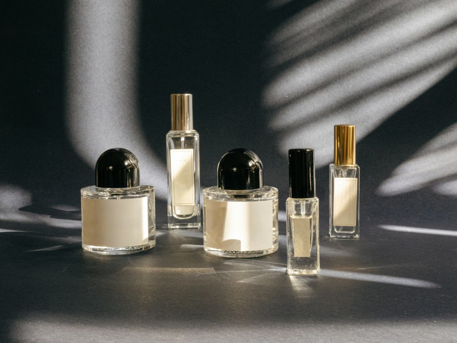Fragrance bottles on a table in dappled sunlight
