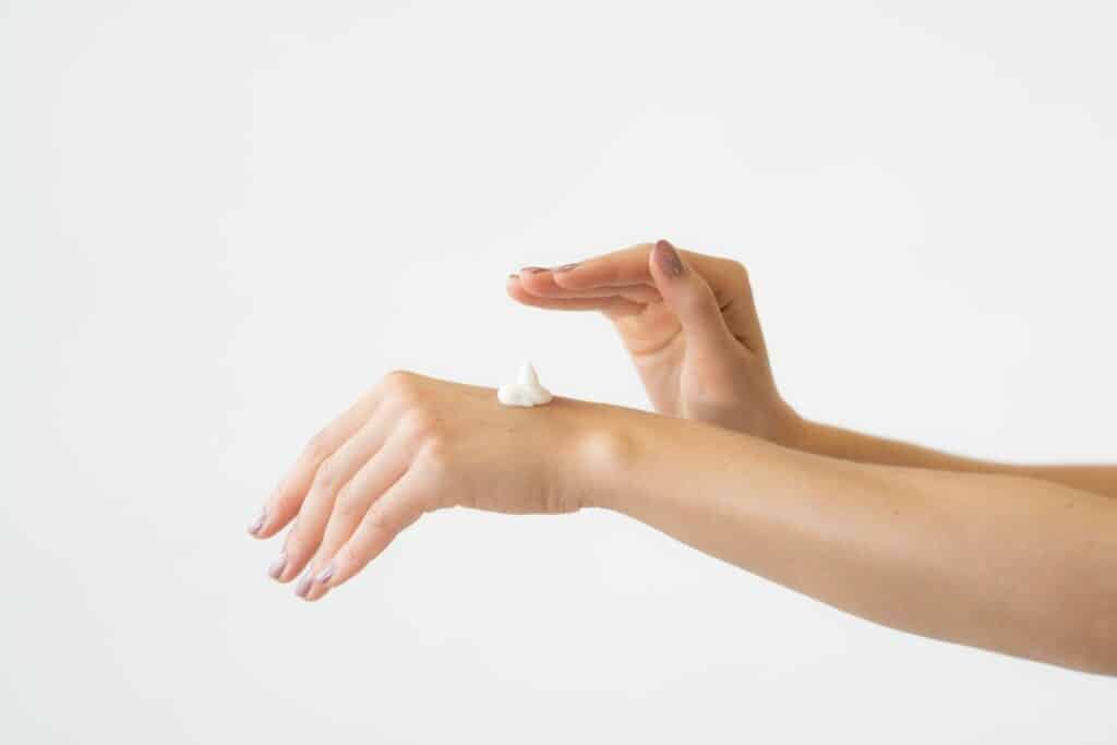 Hand applying a dab of lotion to the back of a wrist