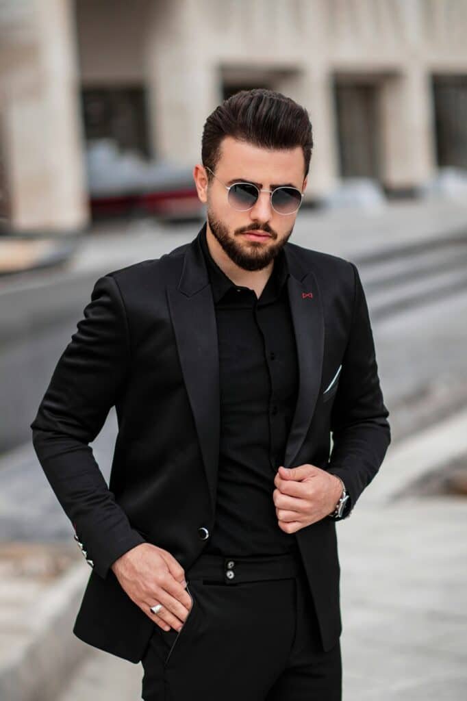 Man in a black suit jacket, black shirt and sunglasses