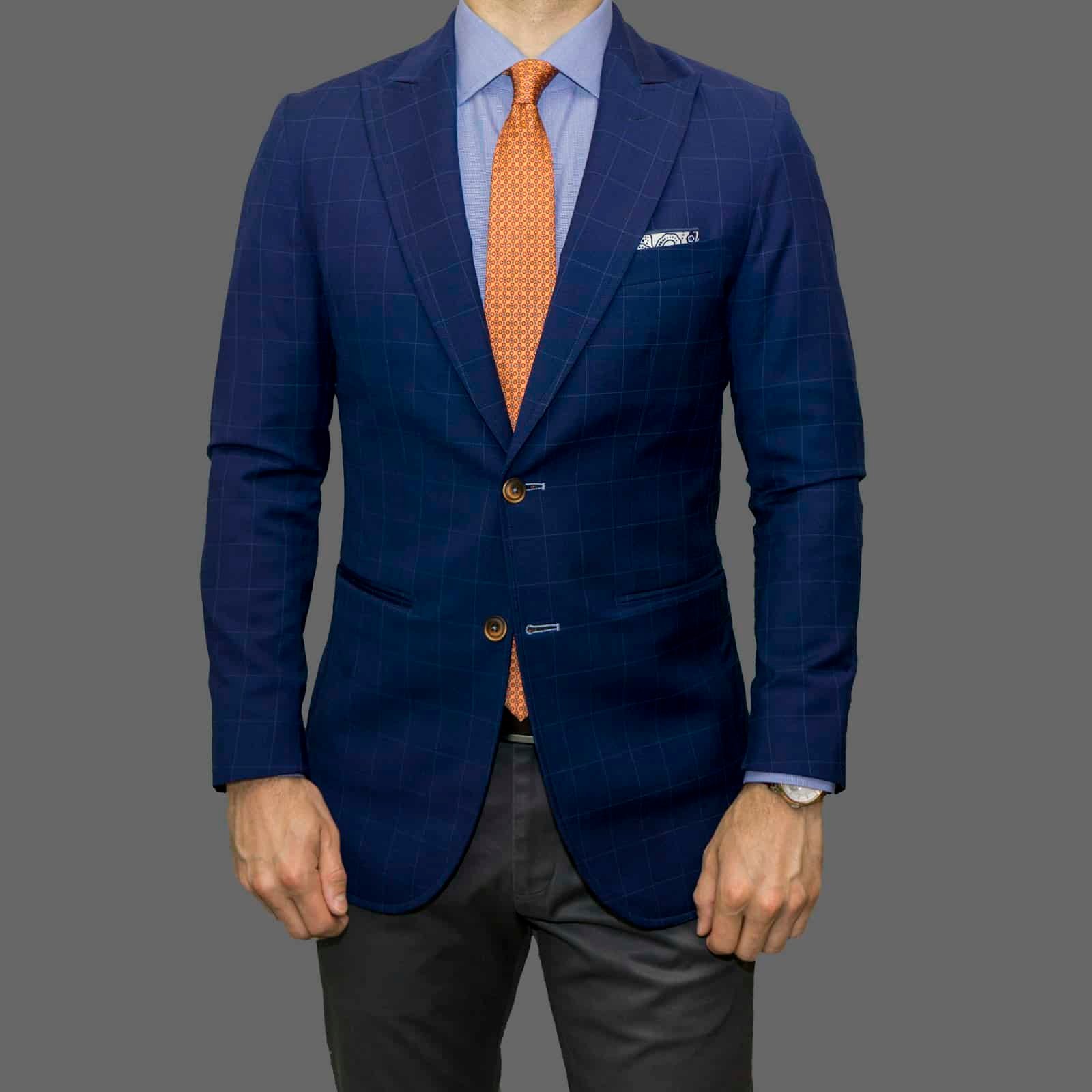 Man in a navy blazer, light blue shirt and orange tie