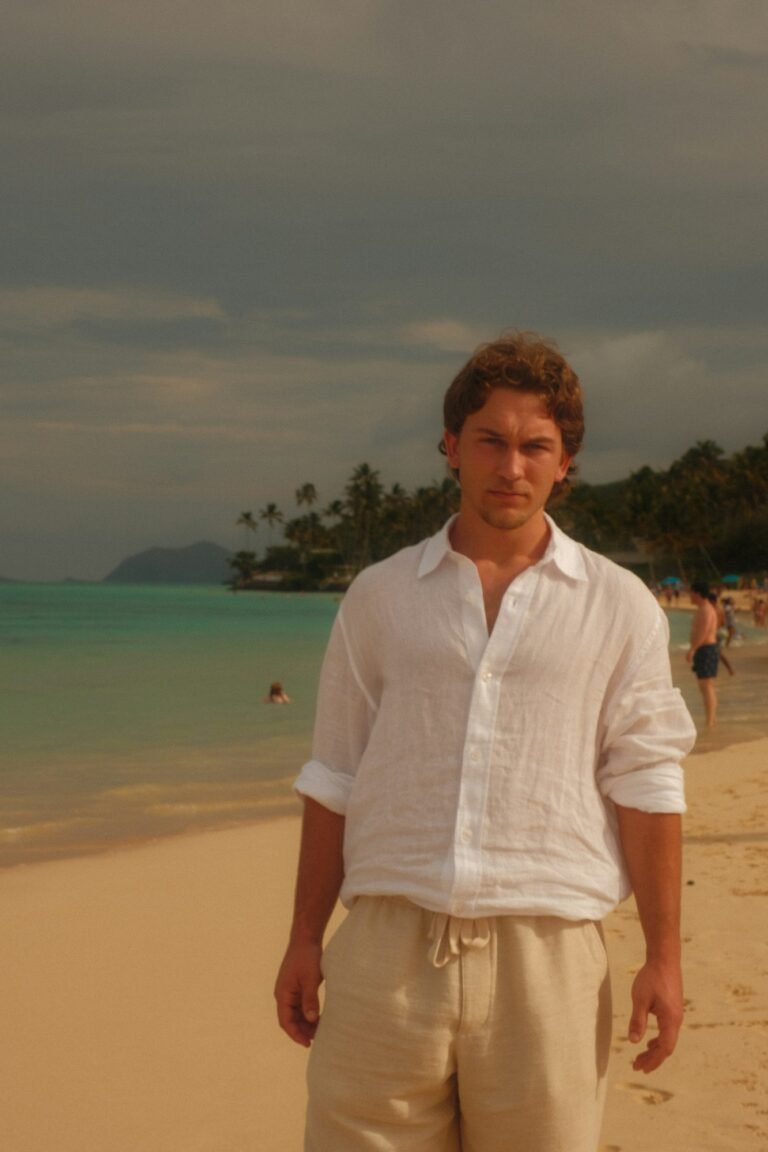 Man in a white linen shirt and light linen trousers on a tropical beach