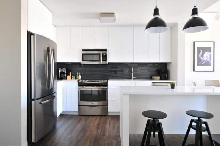 Modern white kitchen with stainless steel appliances and pendant lights