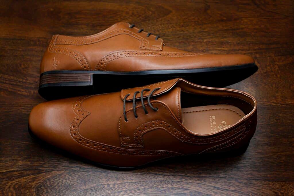 Pair of brown leather brogues on a wooden surface