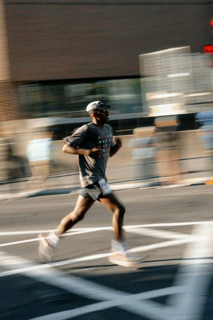 Runner in a gray tee and black shorts on a city street with motion blur