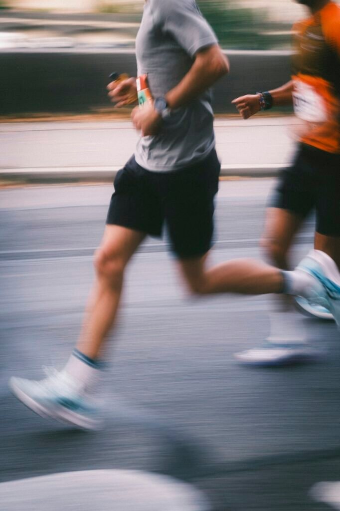 Runners in shorts on a road, blurred by motion