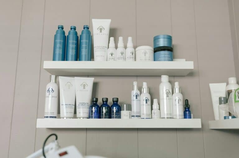 Skincare bottles and jars lined up on white shelves