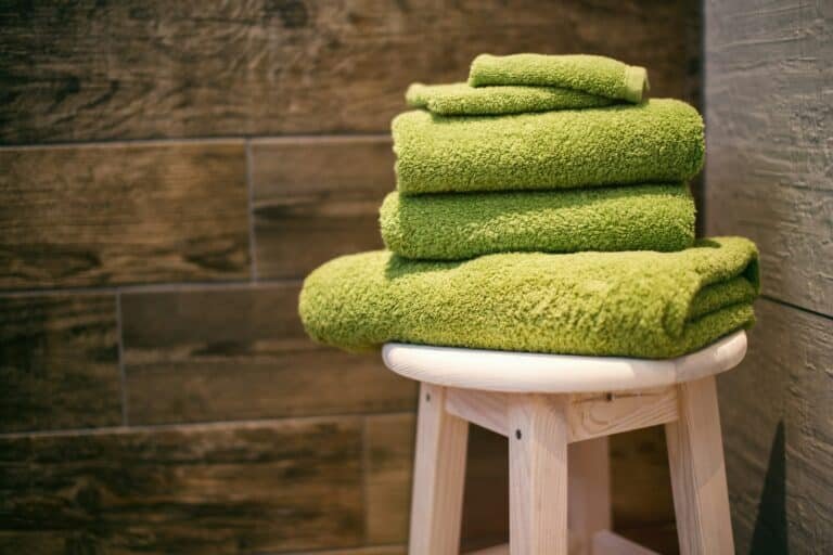 Stack of green towels on a wooden stool