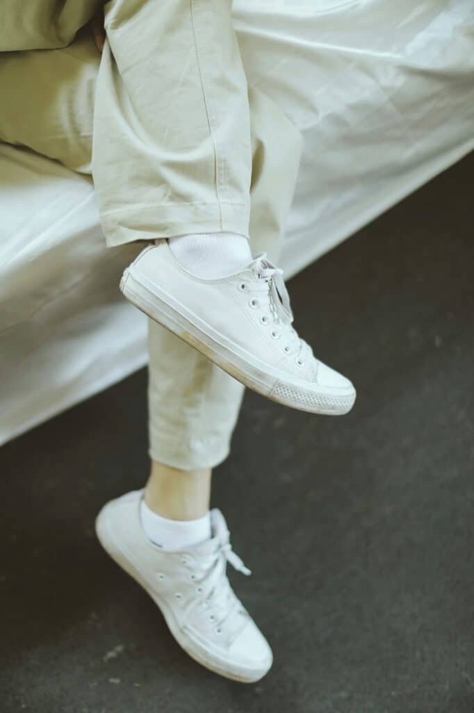 White sneakers worn with cream trousers