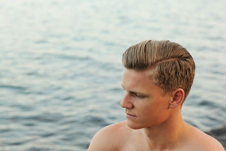 Young man with side-parted hair by the water