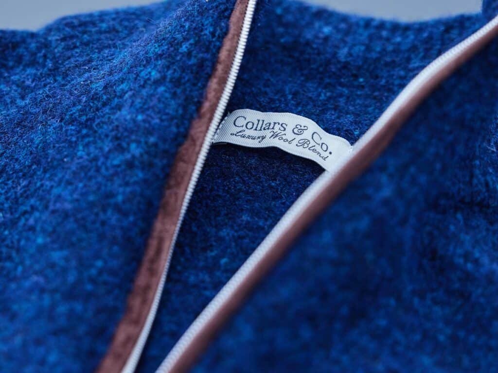 Close-up of the Collars & Co Balmoral quarter zip collar, suede zipper trim and Luxury Wool Blend label