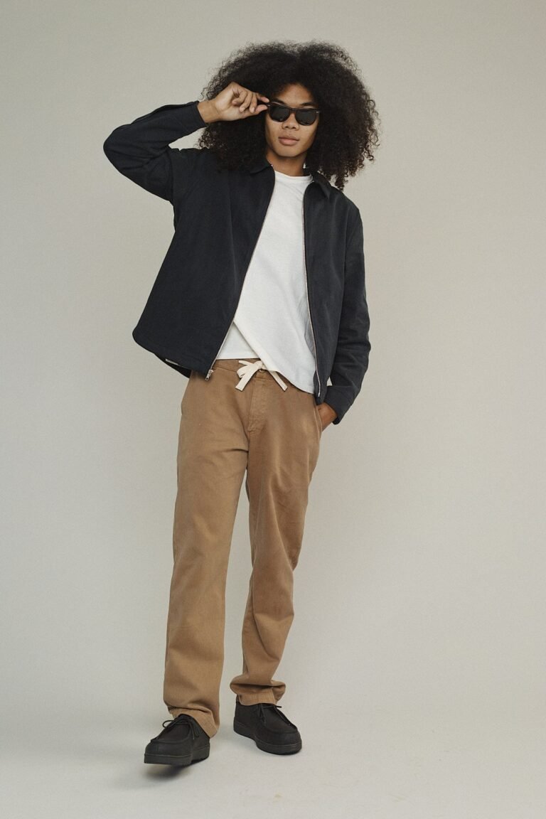 Jungmaven Pacific Coast Pant in tan, worn with a dark jacket and black shoes.